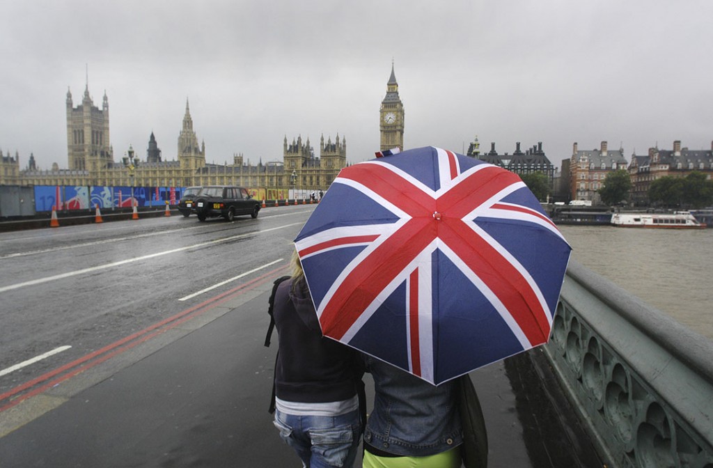 Unpredictable British weather often includes heavy rain fall - illustrated by tourists with union jack umbrella