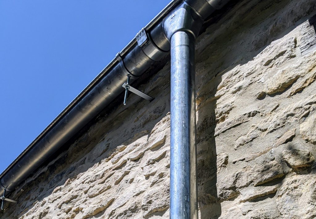 Natural Zinc guttering on rise and fall brackets and Outlet and Downpipe insitu